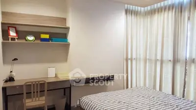 Cozy bedroom with study area, featuring modern decor and ample natural light through large windows.