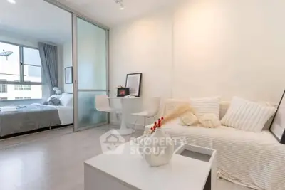 Modern open-plan living room with cozy decor and bedroom view