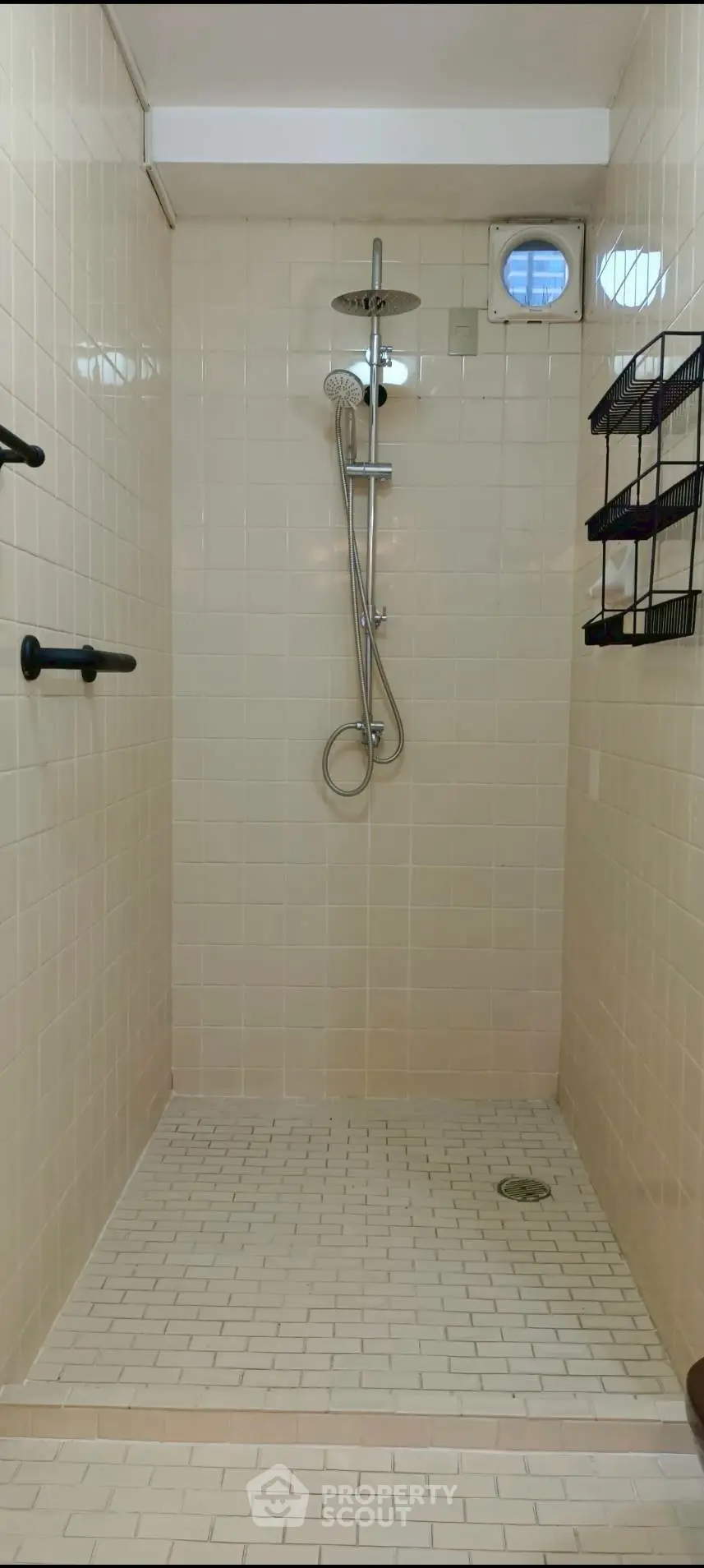 Spacious shower area with modern fixtures and tiled walls