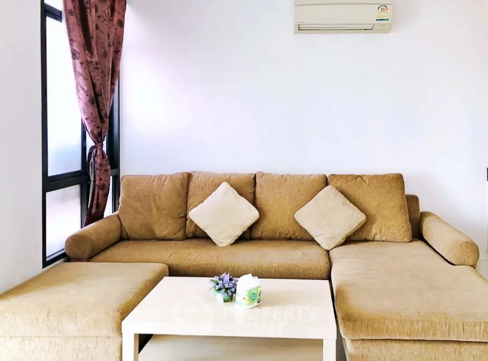 Cozy living room with stylish sofa and air conditioning, perfect for relaxation.