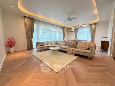 Spacious modern living room with elegant lighting and large windows.