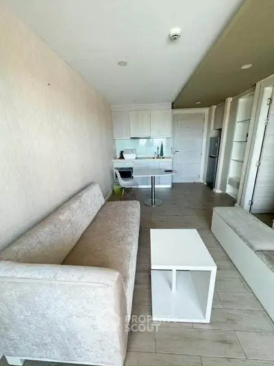 Modern living room with sleek furniture and open kitchen layout in a stylish apartment.