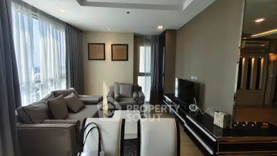 Spacious modern living room with elegant furniture and large windows offering city views.