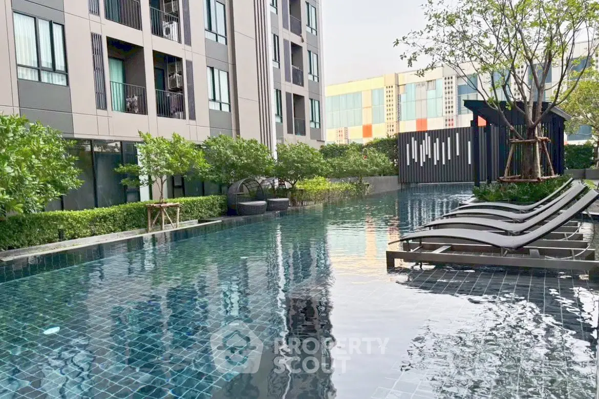 Luxurious condominium pool area with modern design and lush greenery, perfect for relaxation and leisure.