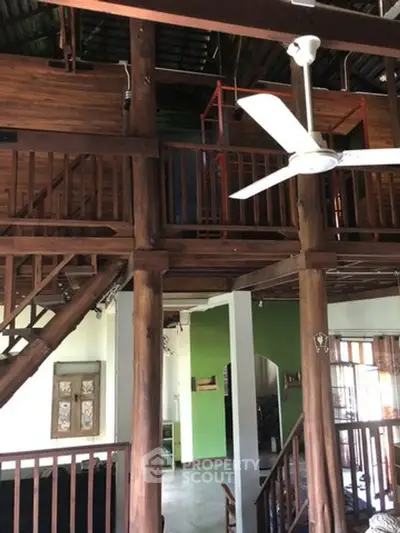 Charming rustic interior with wooden beams and ceiling fan, perfect for cozy living.