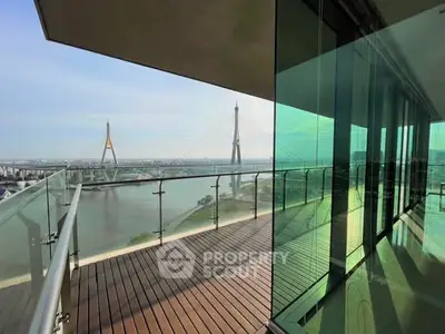 Stunning balcony view with river and bridge, modern glass railing, perfect for relaxation.