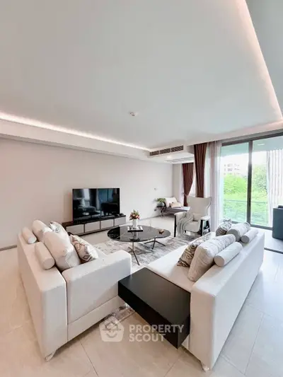 Spacious modern living room with elegant decor and large windows offering natural light.