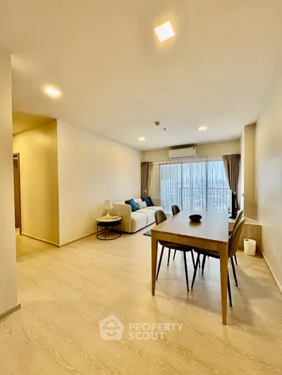 Spacious modern living room with elegant dining area and large windows.