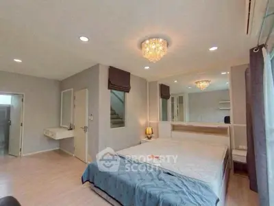 Spacious bedroom with elegant chandelier and modern decor