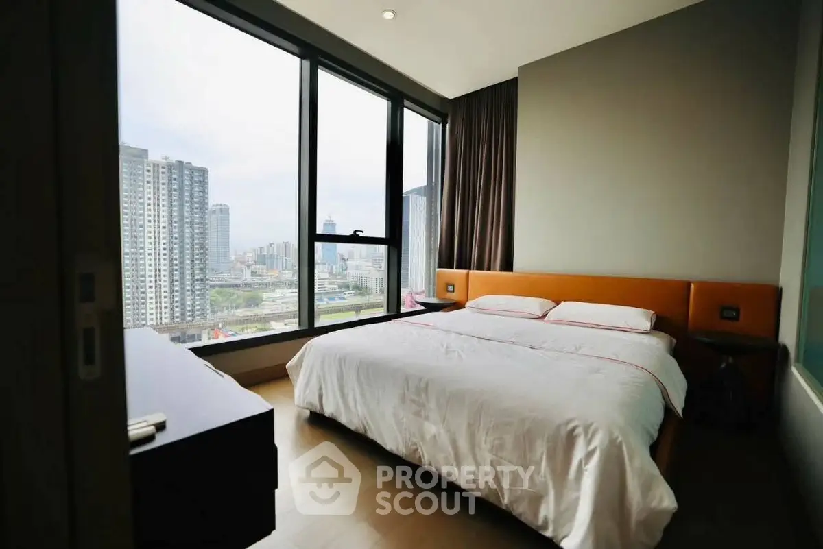 Modern bedroom with large windows offering stunning city views