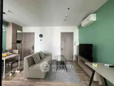 Modern living room with green accent wall, sleek furniture, and air conditioning unit.