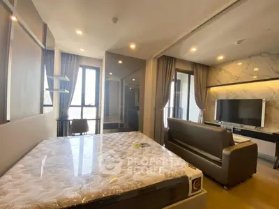 Modern bedroom with large windows, stylish decor, and a cozy seating area, perfect for urban living.
