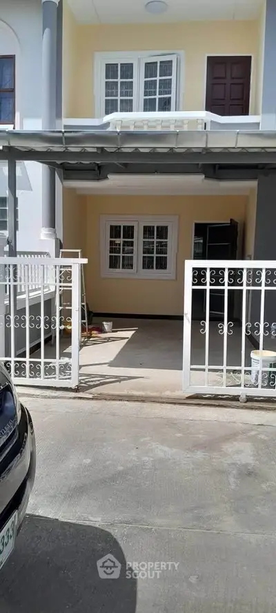 Charming townhouse exterior with gated entrance and driveway, ideal for modern living.