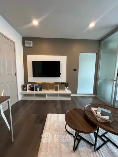 Modern living room with sleek TV setup and stylish coffee tables