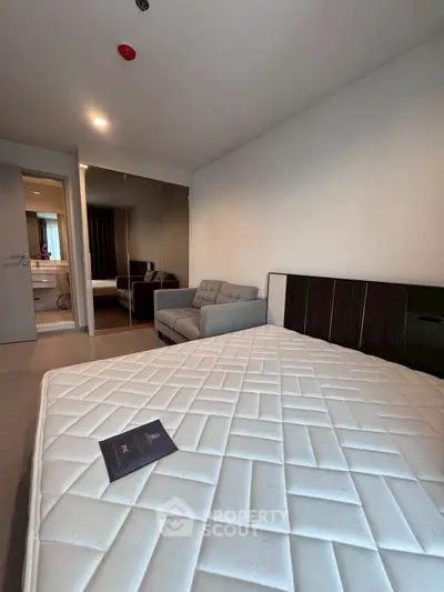 Modern bedroom with mirrored closet and cozy sofa in stylish apartment
