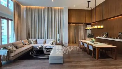 Luxurious open-plan living and dining area with elegant decor and high ceilings.
