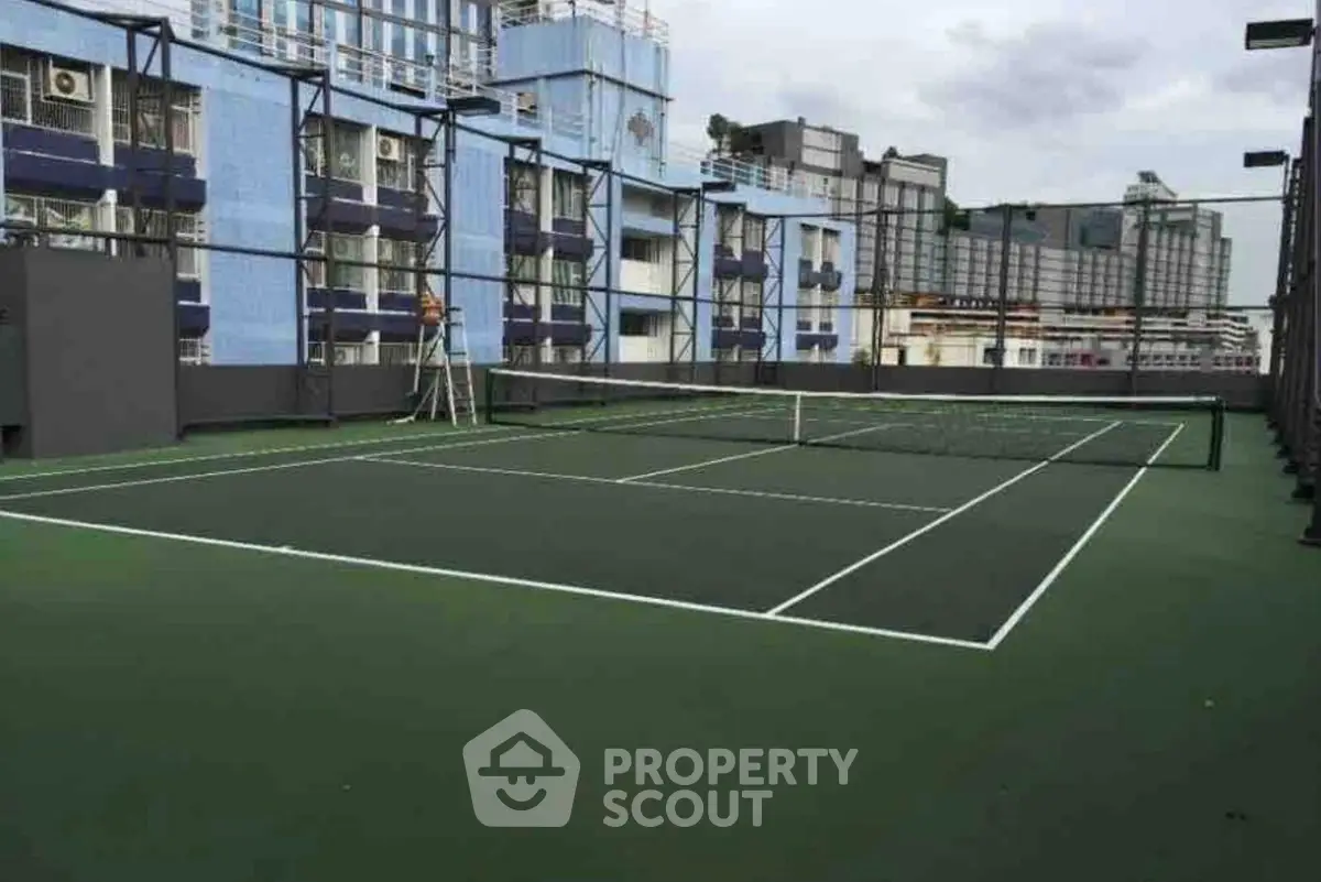 Spacious rooftop tennis court with cityscape views, perfect for urban living enthusiasts.
