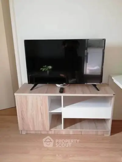 Modern living room with sleek TV stand and flat-screen television, perfect for entertainment.
