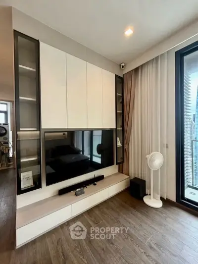 Modern living room with sleek TV unit and large window for natural light