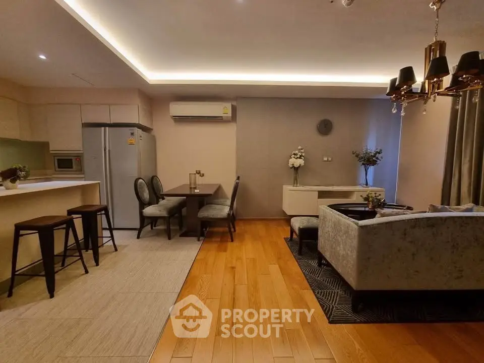 Modern open-layout living room with stylish furniture and wooden flooring