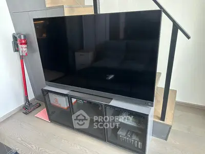 Modern living room with sleek TV setup and stylish staircase