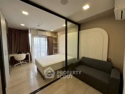Modern bedroom with glass partition, cozy sofa, and study desk