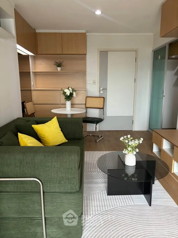 Modern living room with green sofa, stylish decor, and wooden accents in a cozy apartment.