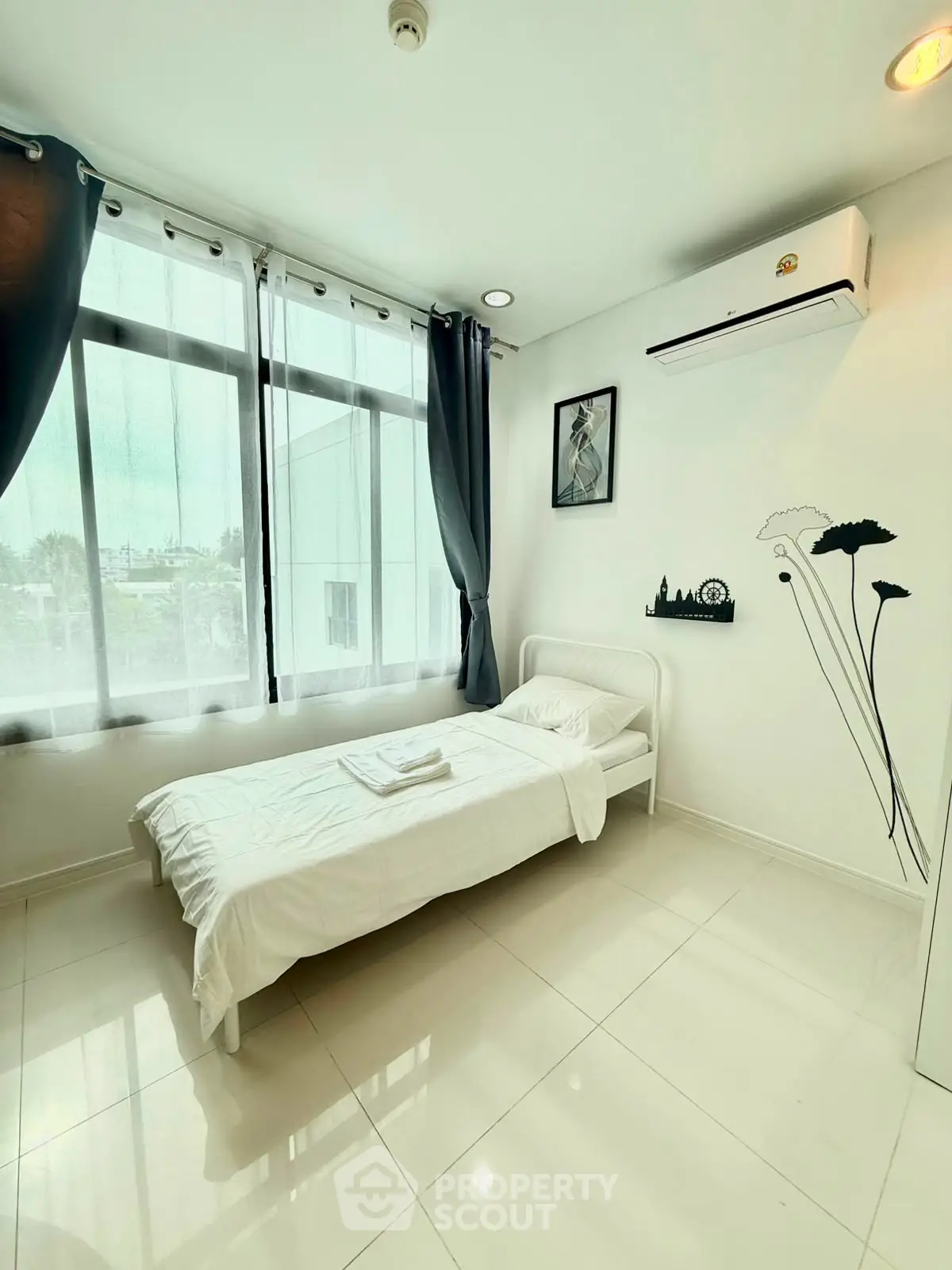 Bright minimalist bedroom with large windows and air conditioning
