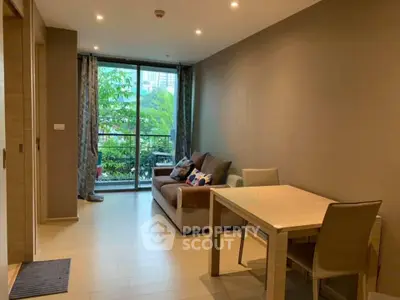Modern living room with cozy sofa and dining area, featuring large windows and natural light.