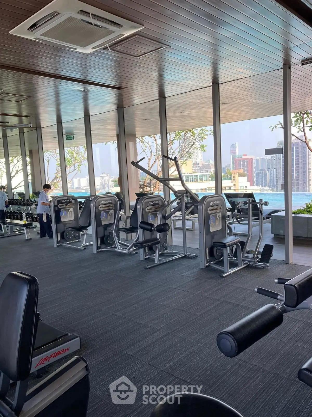 Modern gym with city view and state-of-the-art fitness equipment in a high-rise building.