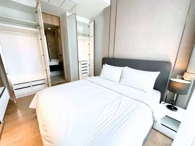Modern bedroom with sleek design and ample storage in a luxurious apartment.