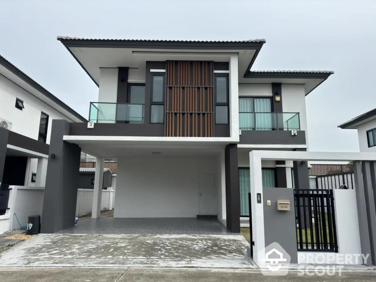 Modern two-story house with sleek design and spacious carport in a suburban neighborhood.