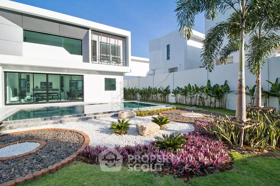 Luxurious modern home with pool and landscaped garden in a serene neighborhood.