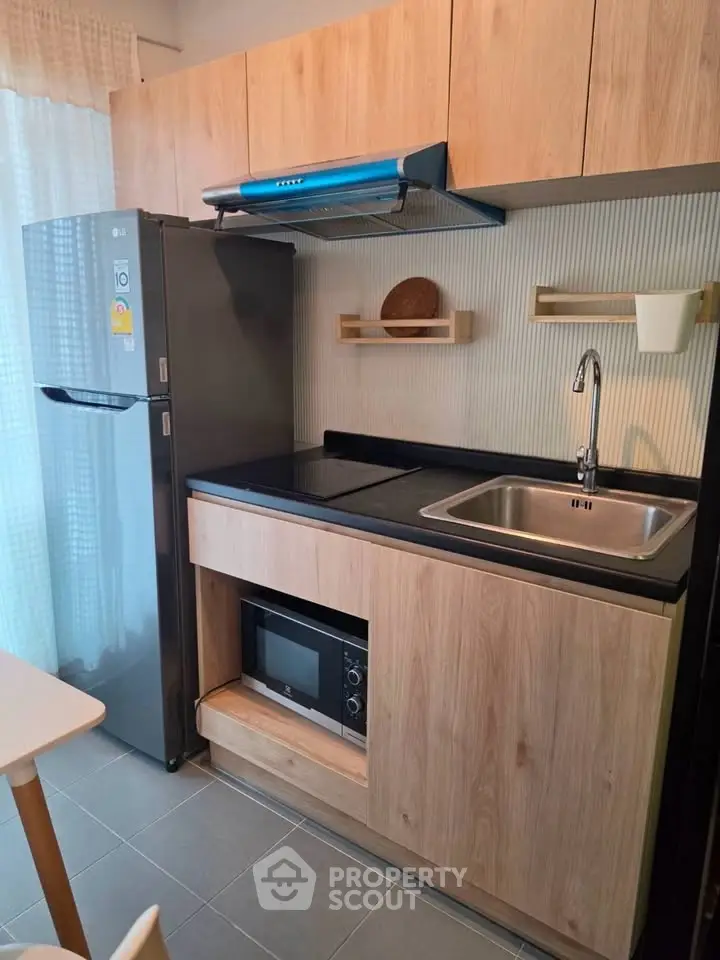 Modern compact kitchen with wooden cabinets, sleek appliances, and stylish backsplash.