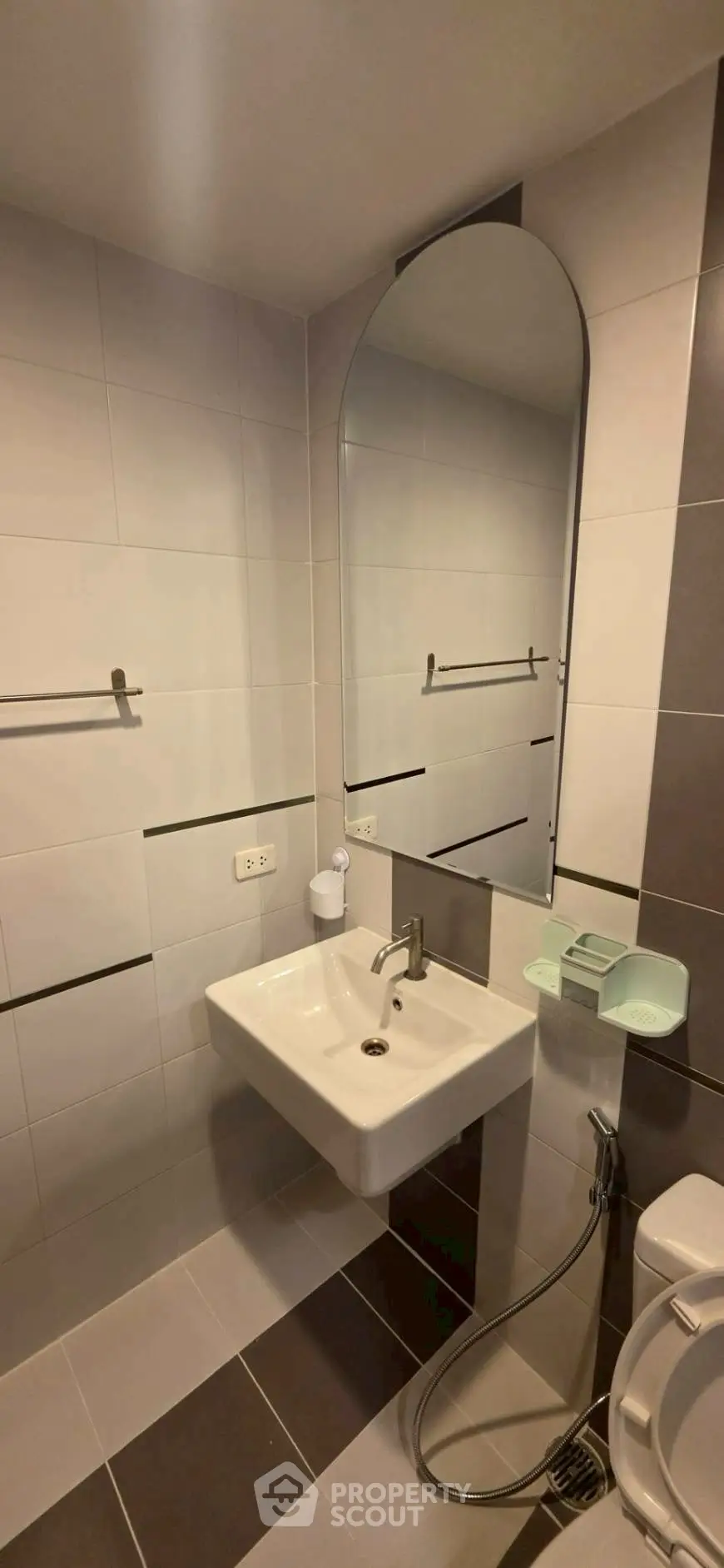 Modern bathroom with sleek sink and large mirror in contemporary apartment.