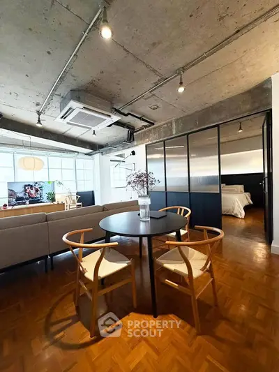 Stylish open-plan living room with modern industrial design and cozy dining area.