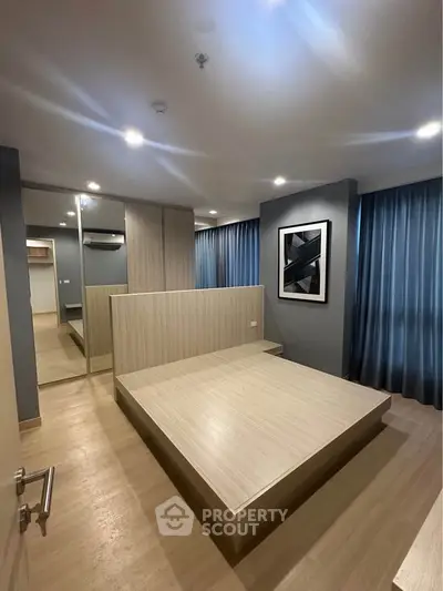 Modern bedroom with wooden flooring, built-in bed frame, and stylish decor in a contemporary apartment.