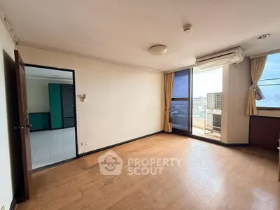 Spacious living room with wooden flooring and balcony access in modern apartment