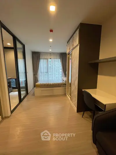 Modern studio apartment with sleek design, featuring a cozy bed, study area, and large windows for natural light.