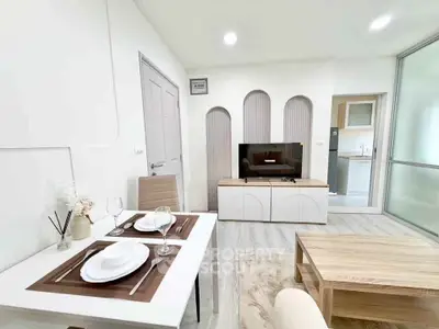 Modern living room with dining area and TV, featuring sleek design and open kitchen layout.