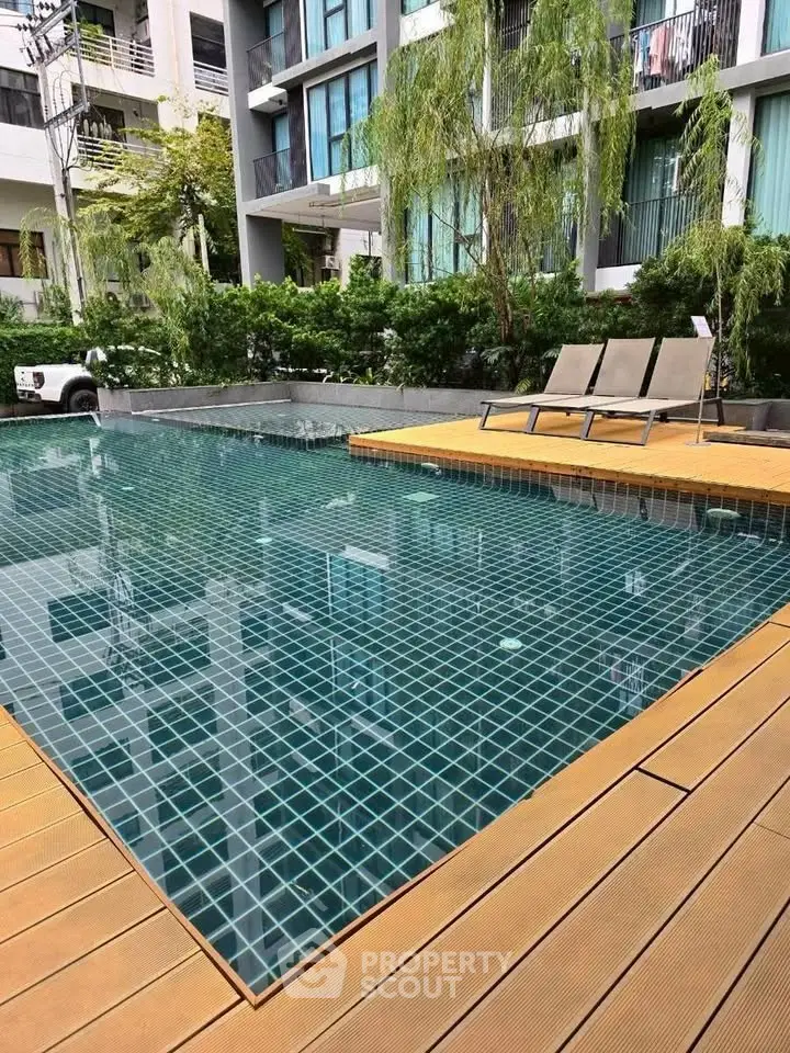 Luxurious apartment pool area with modern design and relaxing lounge chairs.