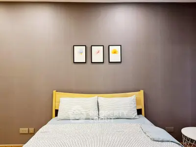 Cozy bedroom with modern decor and striped bedding, perfect for relaxation.