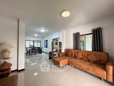 Spacious living room with modern brown sofa and elegant decor in a bright, open layout home.