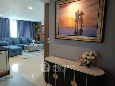 Elegant living room with modern decor and stylish furniture, featuring a large sectional sofa and decorative artwork.