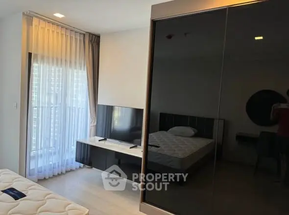 Modern bedroom with sleek black wardrobe and natural light