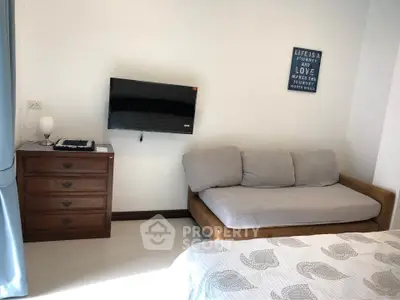 Cozy bedroom with wall-mounted TV and comfortable sofa bed