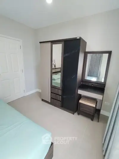 Modern bedroom with sleek wardrobe and vanity set, perfect for stylish living.