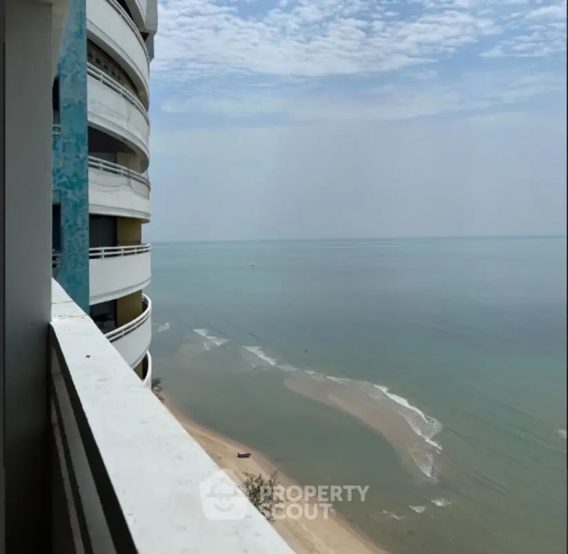 Stunning ocean view from high-rise balcony with serene beach below.
