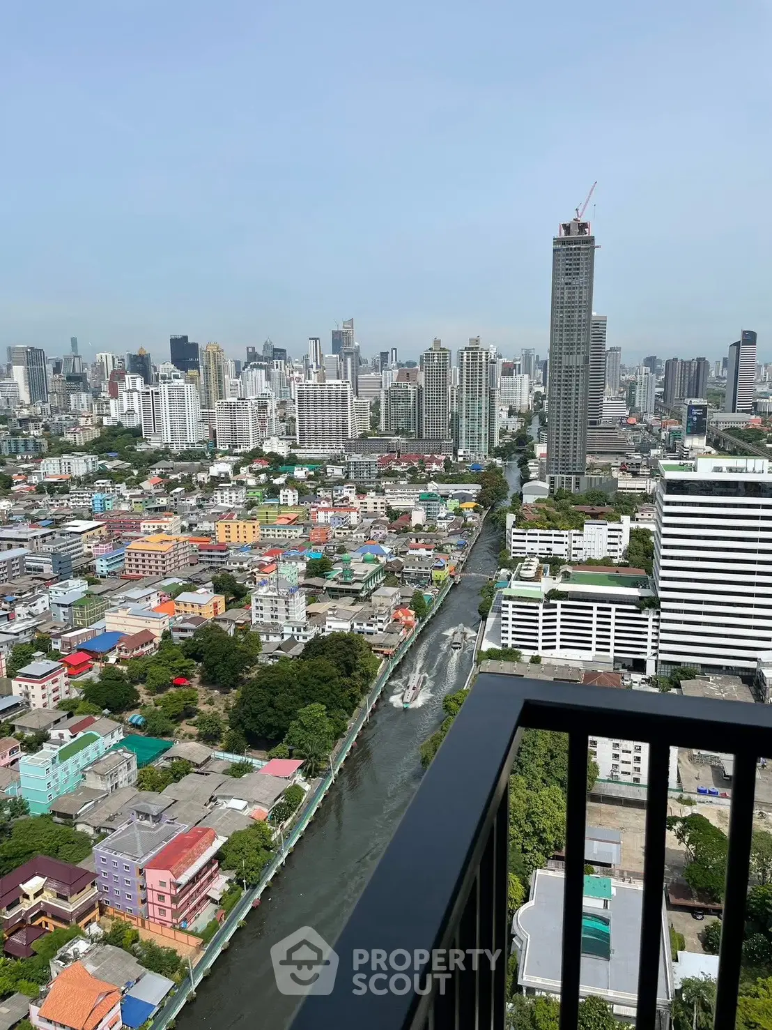 Stunning cityscape view from high-rise balcony overlooking vibrant urban landscape and river.