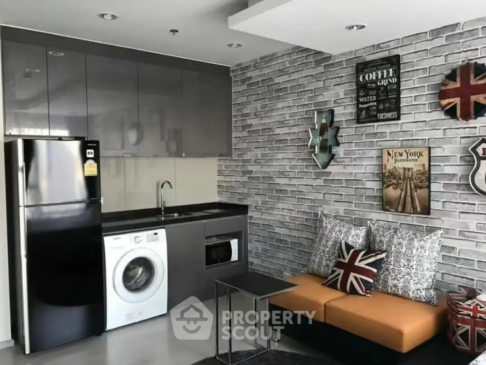 Modern living room with stylish kitchen, washing machine, and chic decor in urban apartment.